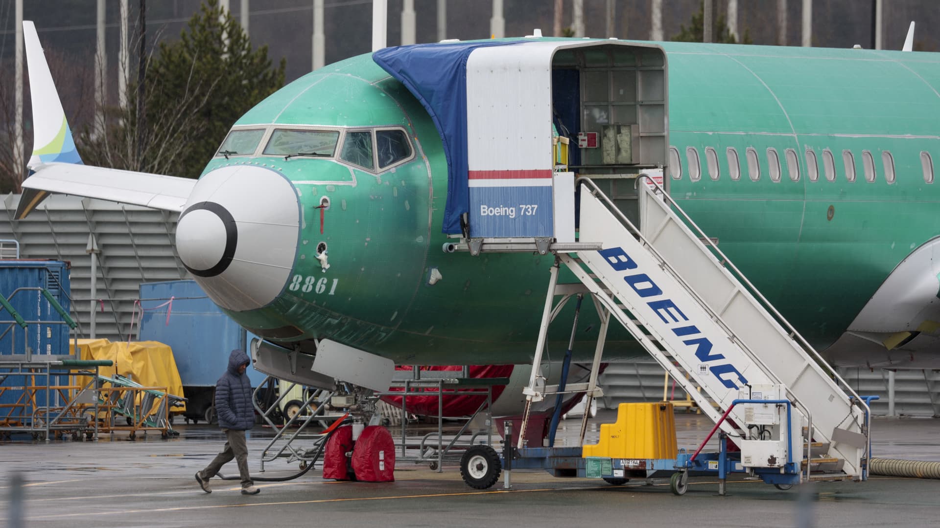 A person walks past an unpainted Boeing 737-8 MAX parked at Renton Municipal Airport adjacent to Boeing's factory in Renton, Washington on January 25, 2024.