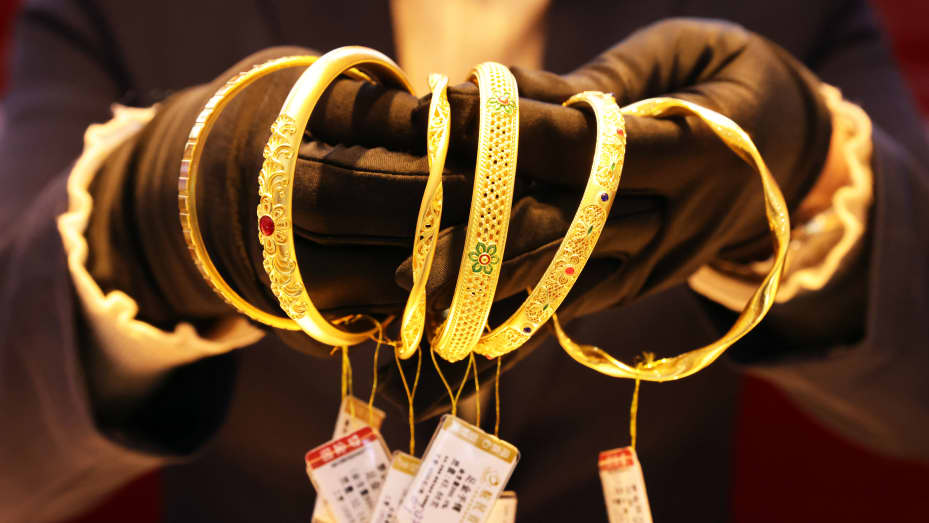 HUZHOU, CHINE - 04 DÉCEMBRE : un employé présente des bracelets en or dans une bijouterie en or le 4 décembre 2023 à Huzhou, province du Zhejiang en Chine.  (Photo de Ni Lifang/VCG via Getty Images)