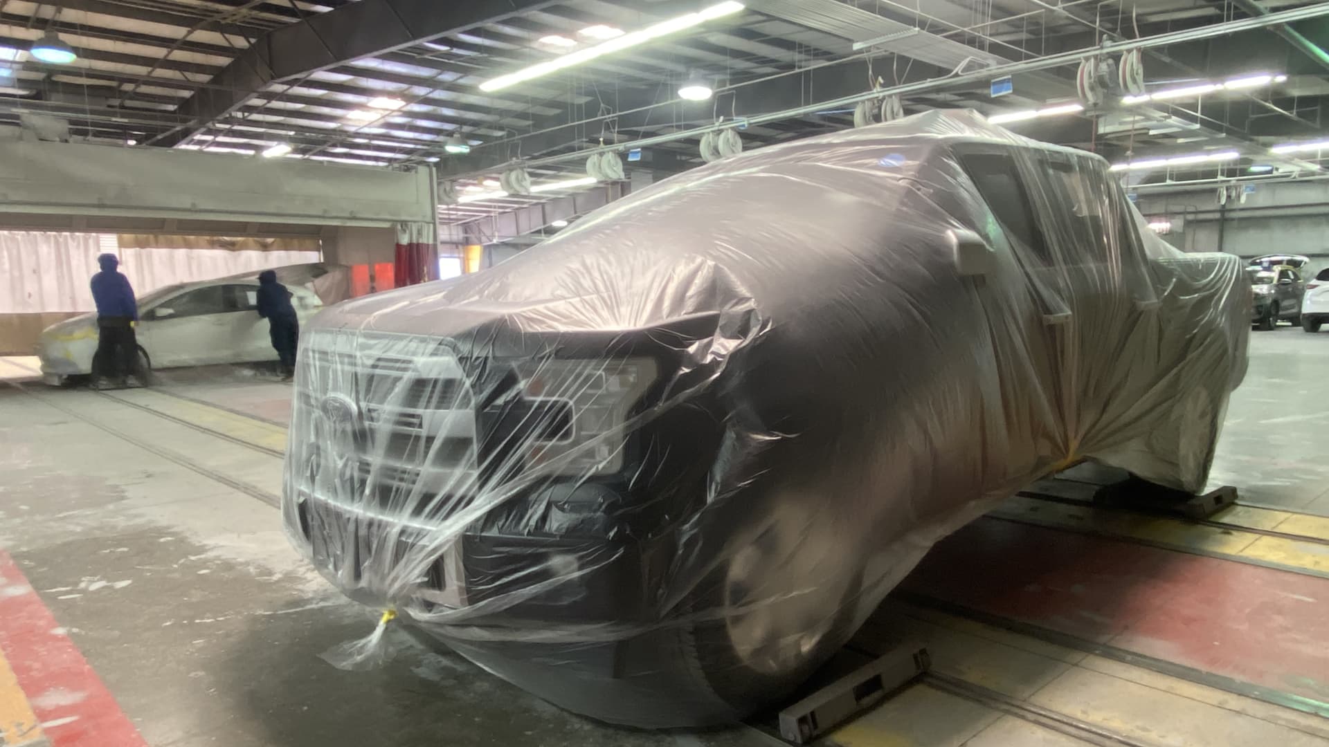 A Ford F-150 is prepped for a painting booth at Carvana's vehicle reconditing center outside Phoenix. The vehicle is wrapped so only the spot needed to be repainted is showing.  