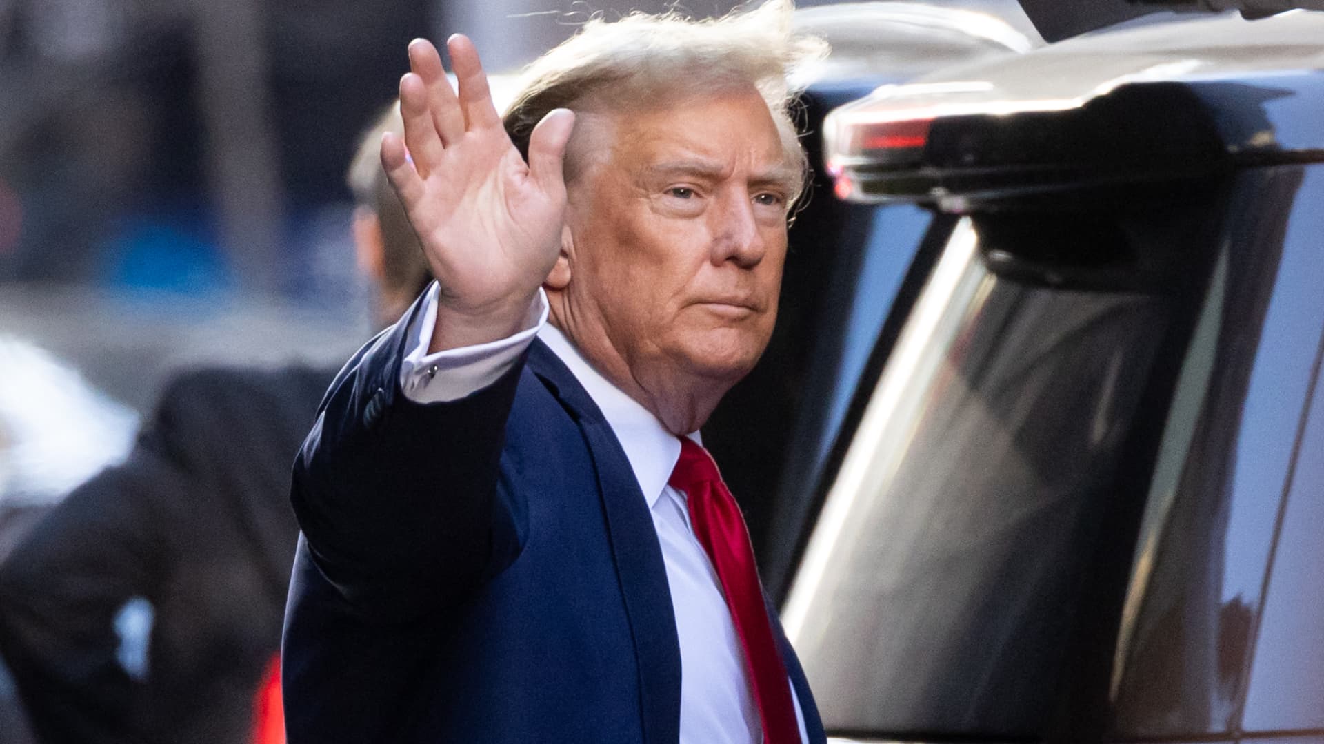 Former US President Donald Trump waves as he departs Trump Tower on his way to Manhattan Criminal Court in New York City on February 15, 2024. 
