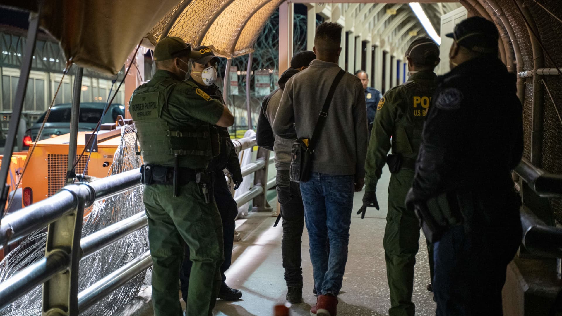U.S. agents escort asylum applicants down to the U.S. side of the bridge on April 1, 2020 at the Paso del Norte International Bridge in Ciudad Juarez, Mexico.