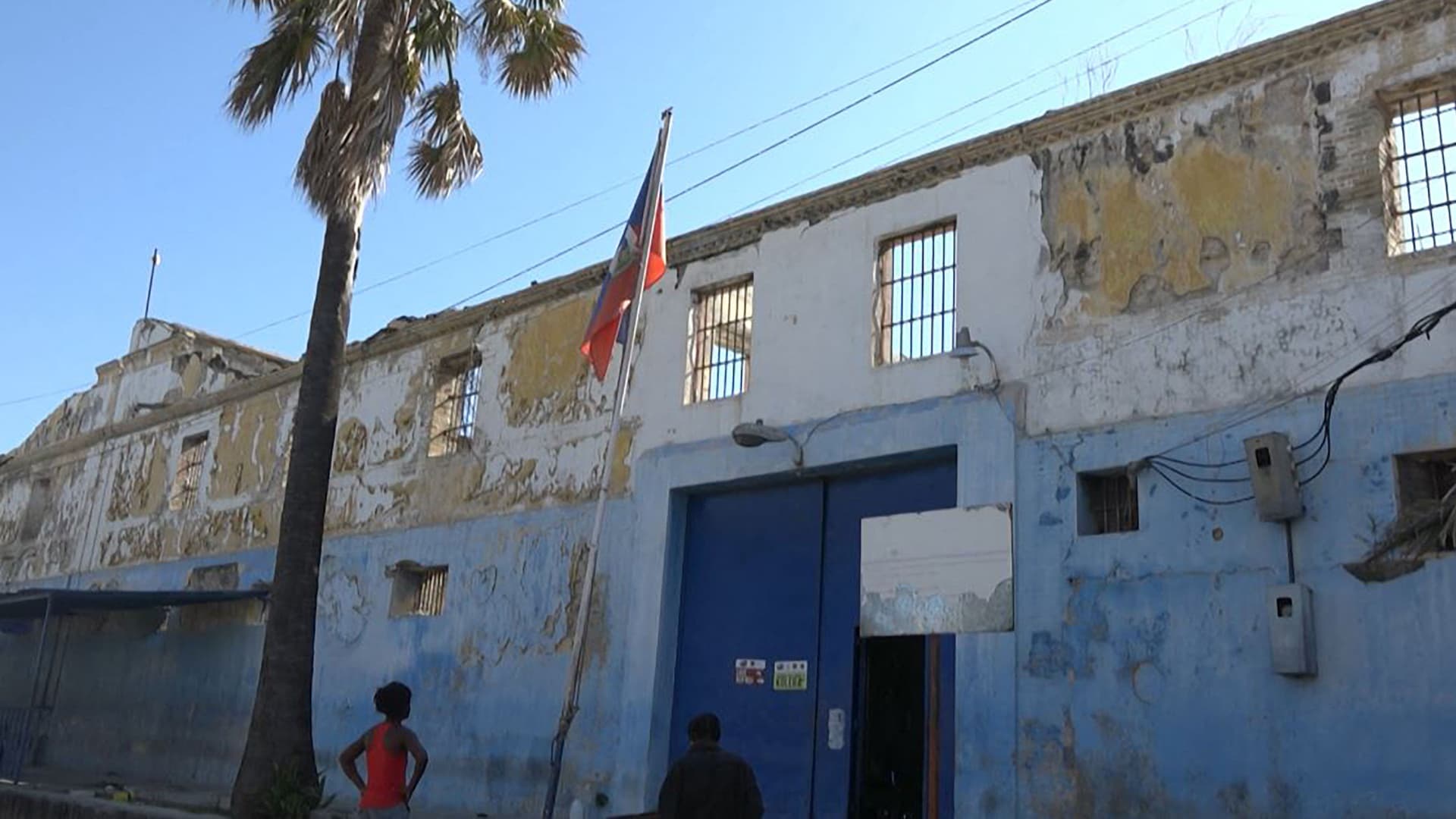 This screen grab taken from AFPTV shows people looking at the building of the main prison of Port-au-Prince, Haiti, on March 3, 2024, after a breakout by several thousand inmates.