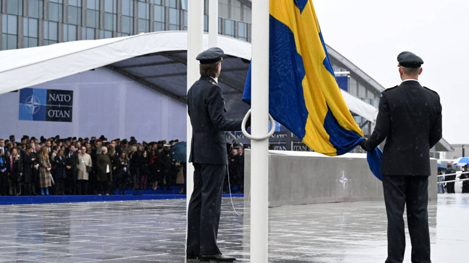 Officials prepare to hoist the Swedish national flag during a flag raising ceremony for Sweden's accession to NATO at the North Atlantic Alliance headquarters in Brussels, on March 11, 2024. 