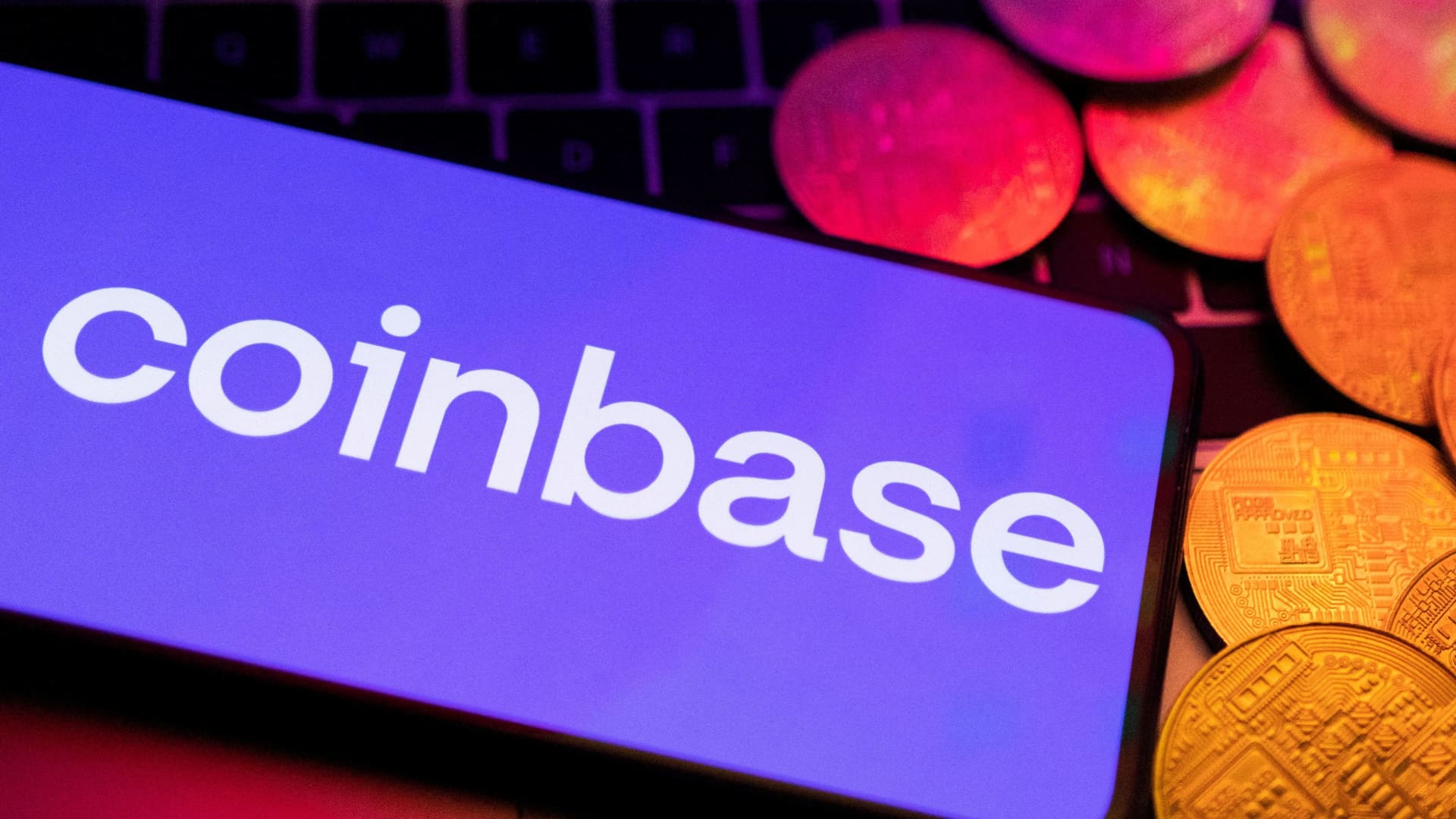 A smartphone with displayed Coinbase logo and representation of cryptocurrencies are placed on a keyboard in this illustration taken, June 8, 2023.