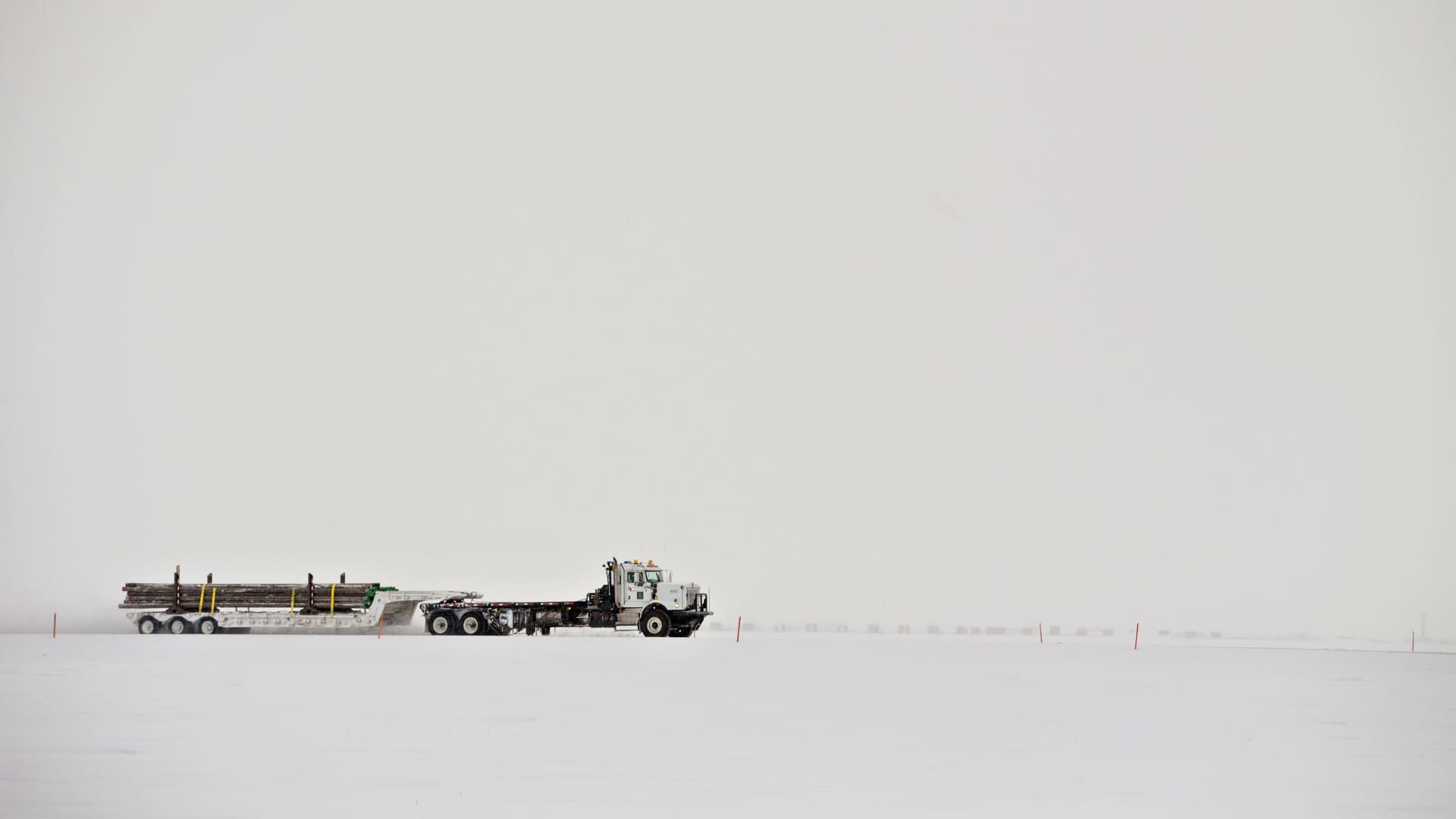 A truck carries a load of pipes along a snow covered road in Prudhoe Bay, Alaska, U.S., on Thursday, Feb. 16, 2017. 