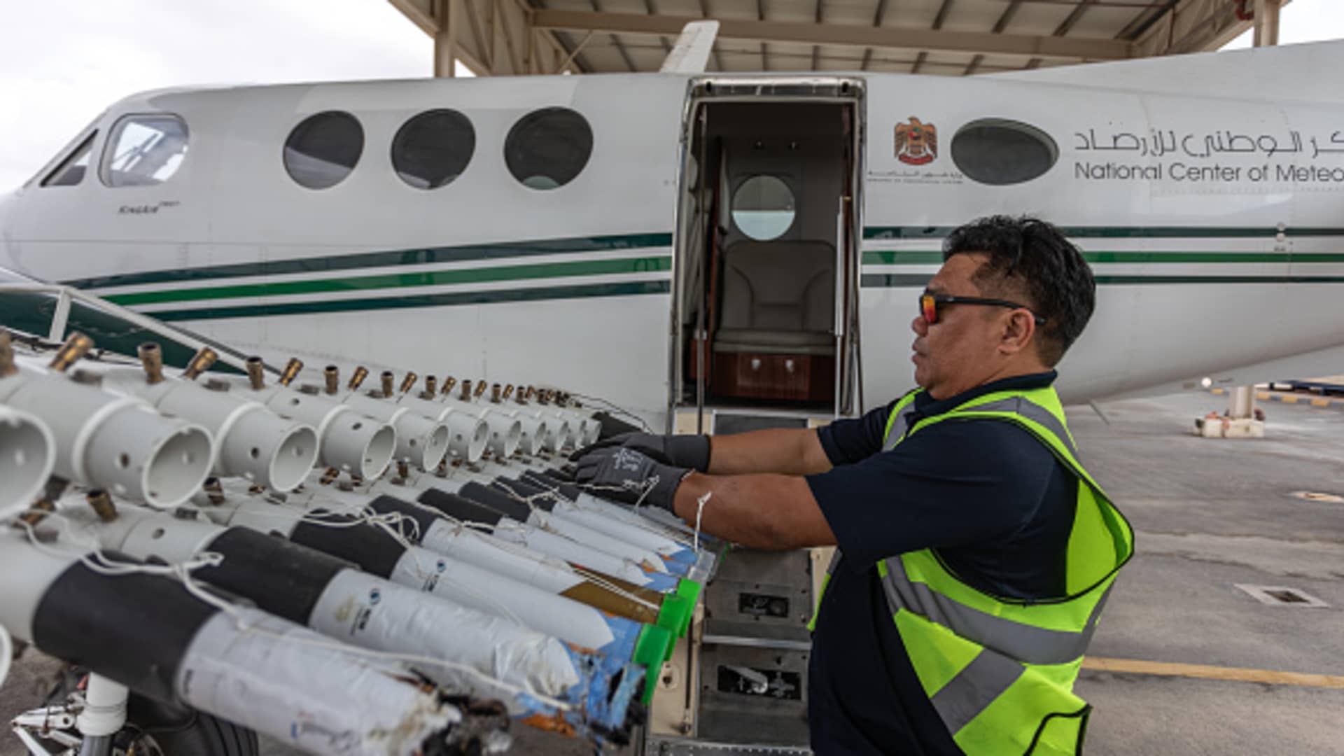 = A ground engineer restocking one of the UAE's National Center of Meteorology cloud-seeding planes with new Hygroscopic salt flares on January 31, 2024 in Al Ain, United Arab Emirates. 