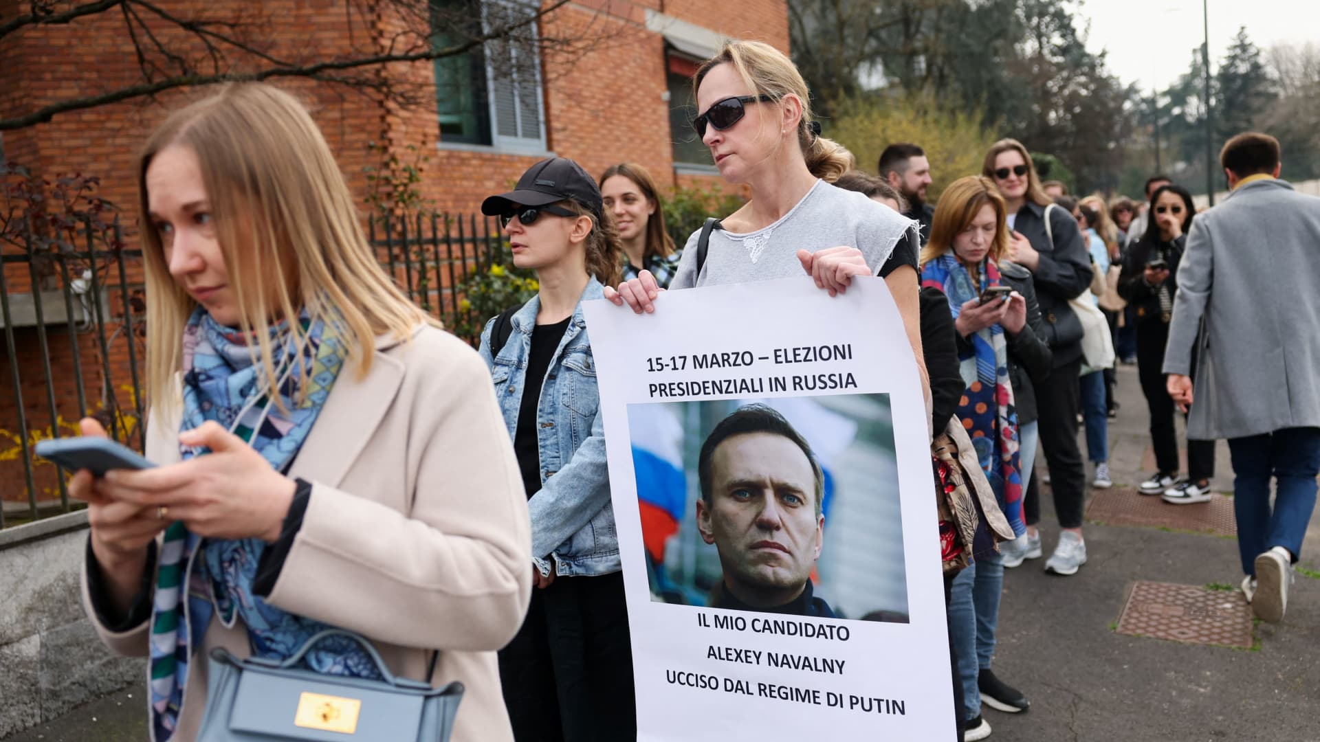 A woman holds a placard with a photo of late Russian opposition leader Alexei Navalny outside the Russian Consulate, on the final day of the presidential election in Russia, amid Russia's attack on Ukraine, in Milan, Italy, March 17, 2024.