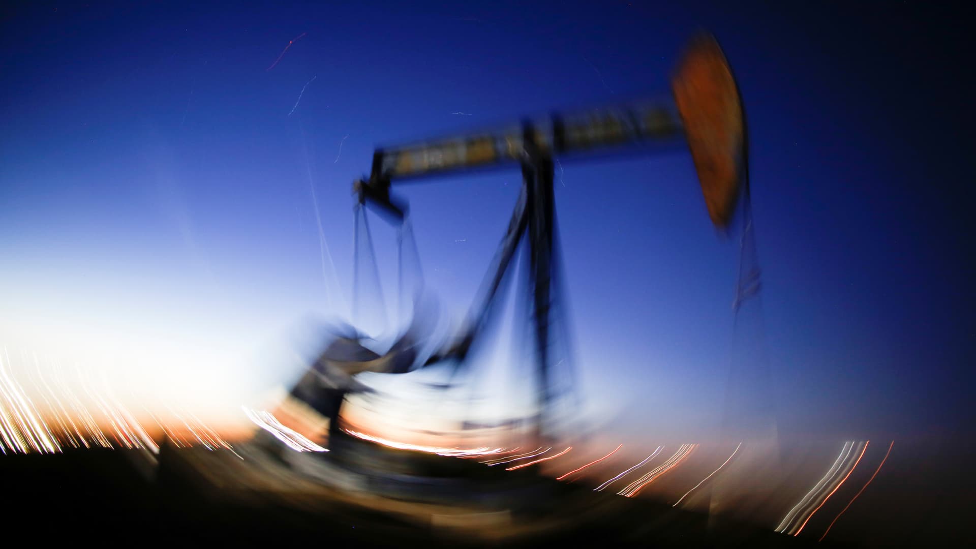 A long exposure image shows the movement of a crude oil pump jack in the Permian Basin in Loving County, Texas.