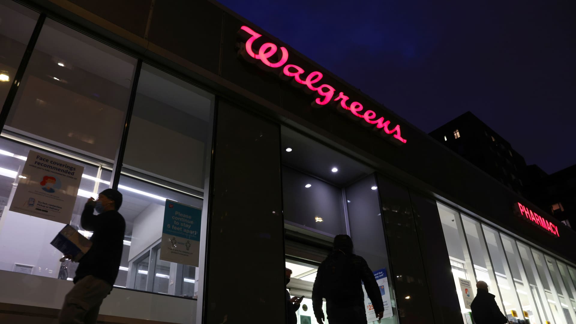 People walk by a Walgreens, owned by the Walgreens Boots Alliance, Inc., in Manhattan, New York City, U.S., November 26, 2021. 