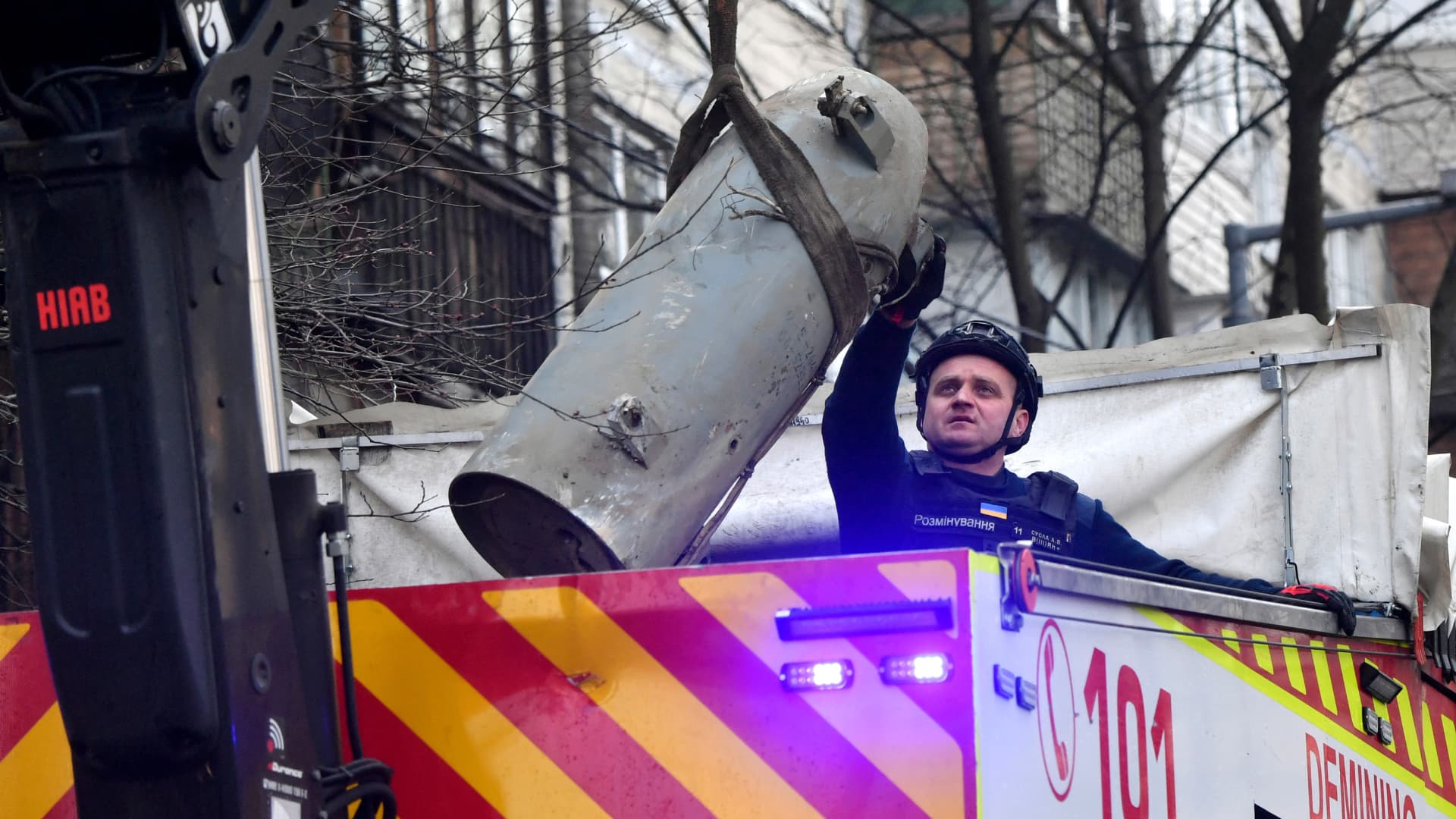 A Ukrainian explosives technician loads a fragment of a missile into a special demining armoured truck outside of five-storey residential building after a missile attack, in Kyiv on March 21, 2024, amid the Russian invasion in Ukraine.