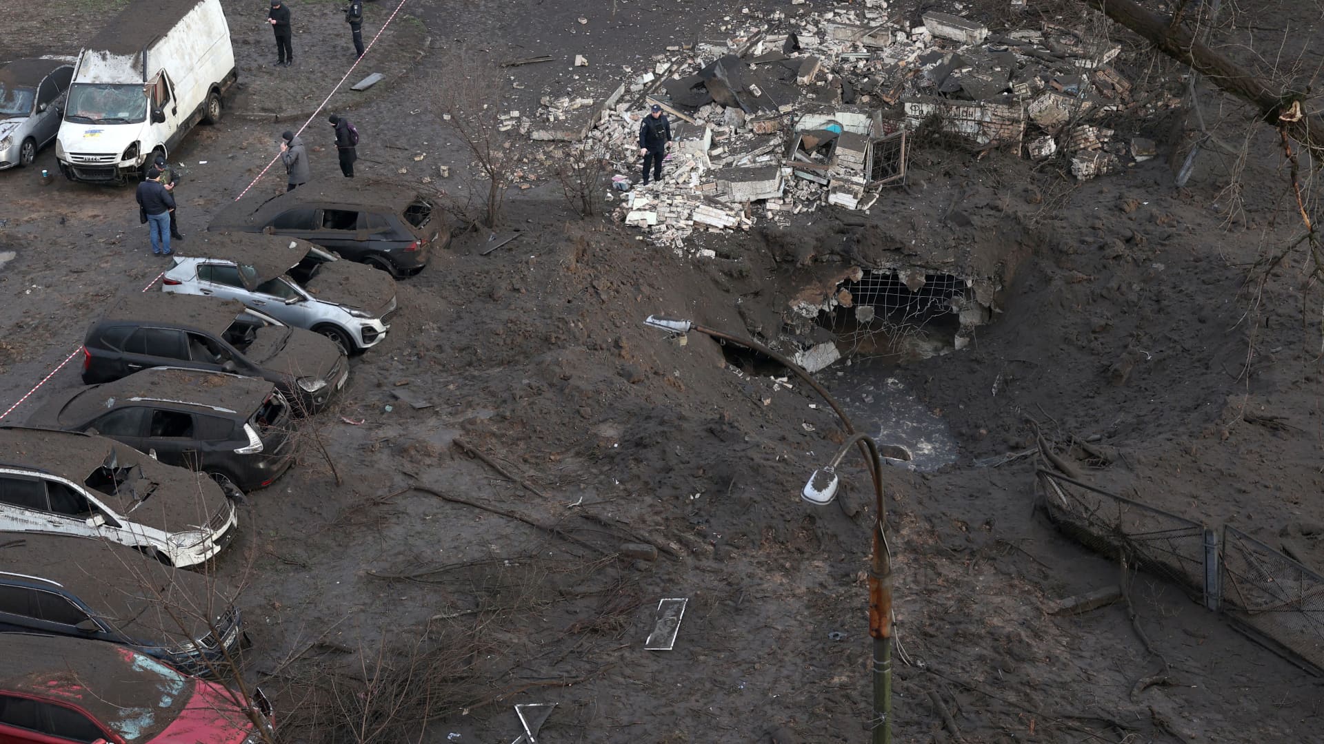 Police officers inspect a crater caused by an explosion after a missile attack in Kyiv, on March 21, 2024, amid the Russian invasion in Ukraine. 