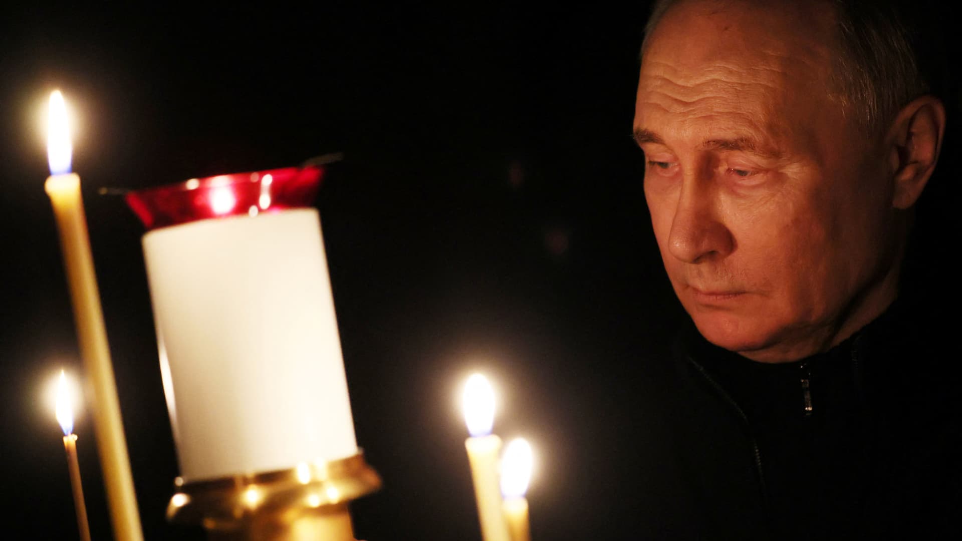 In this pool photograph distributed by the Russian state agency Sputnik, Russia's President Vladimir Putin lights a candle during his visit to a church of the Novo-Ogaryovo state residence outside Moscow on March 24, 2024, as Russia observes a national day of mourning after the Crocus City Hall attack.