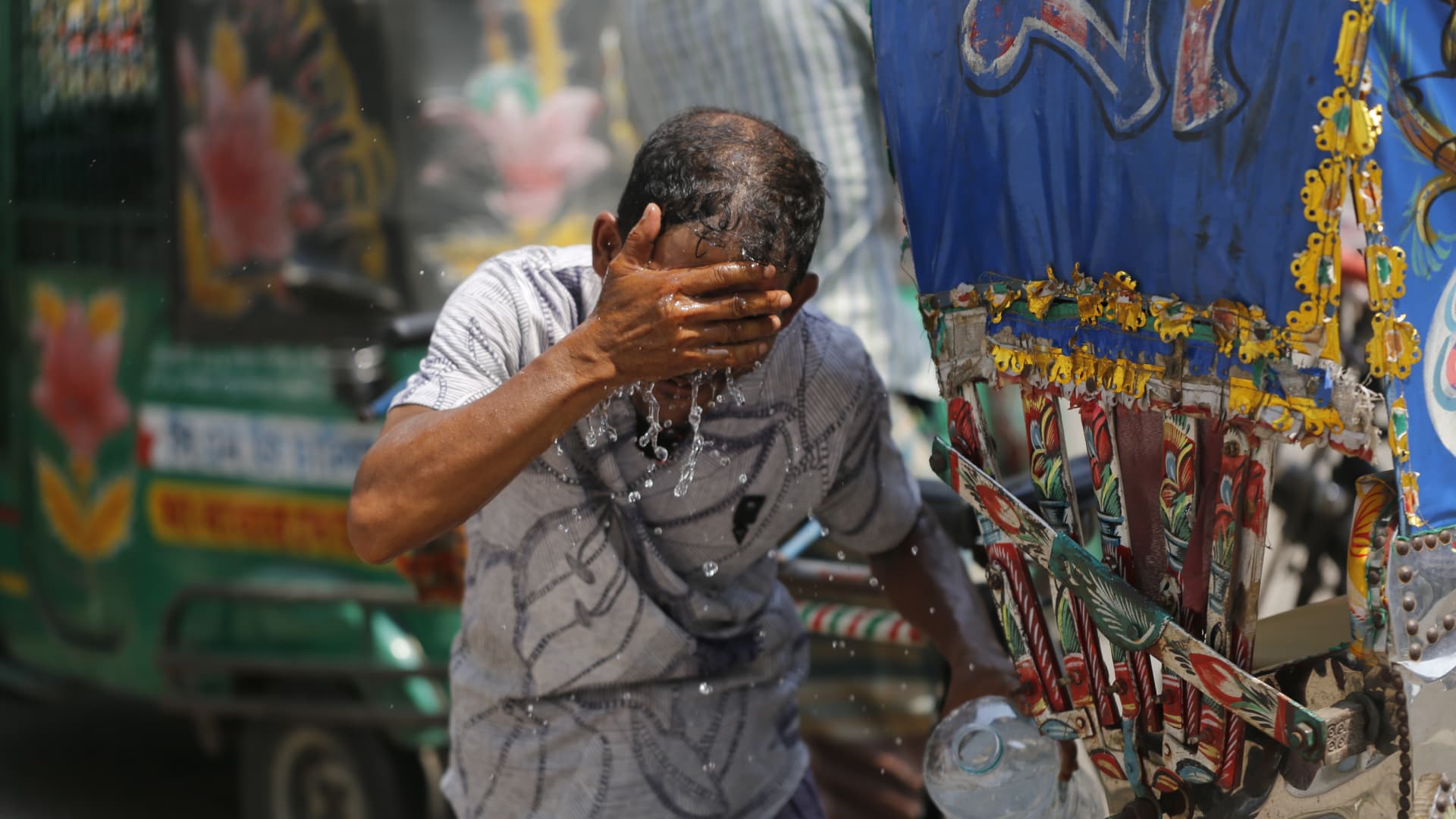 A Rickshaw puller splashes water on his face to get relief during a heatwave in Dhaka, Bangladesh on May 10, 2023.