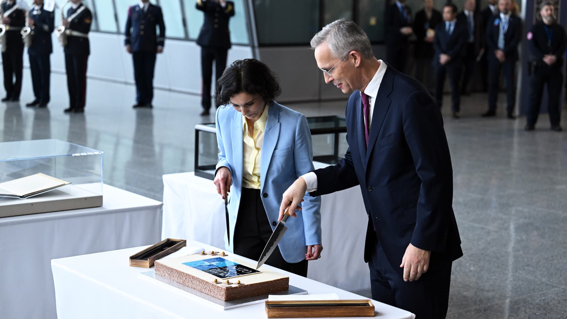 Belgian Foreign Minister Hadja Lahbib (L) and NATO Secretary General Jens Stoltenberg (R) cut a cake during NATO's 75th anniversary ceremony, held in the gathering place called 'Agora' at the NATO headquarters in Brussels, Belgium on April 4, 2024. 