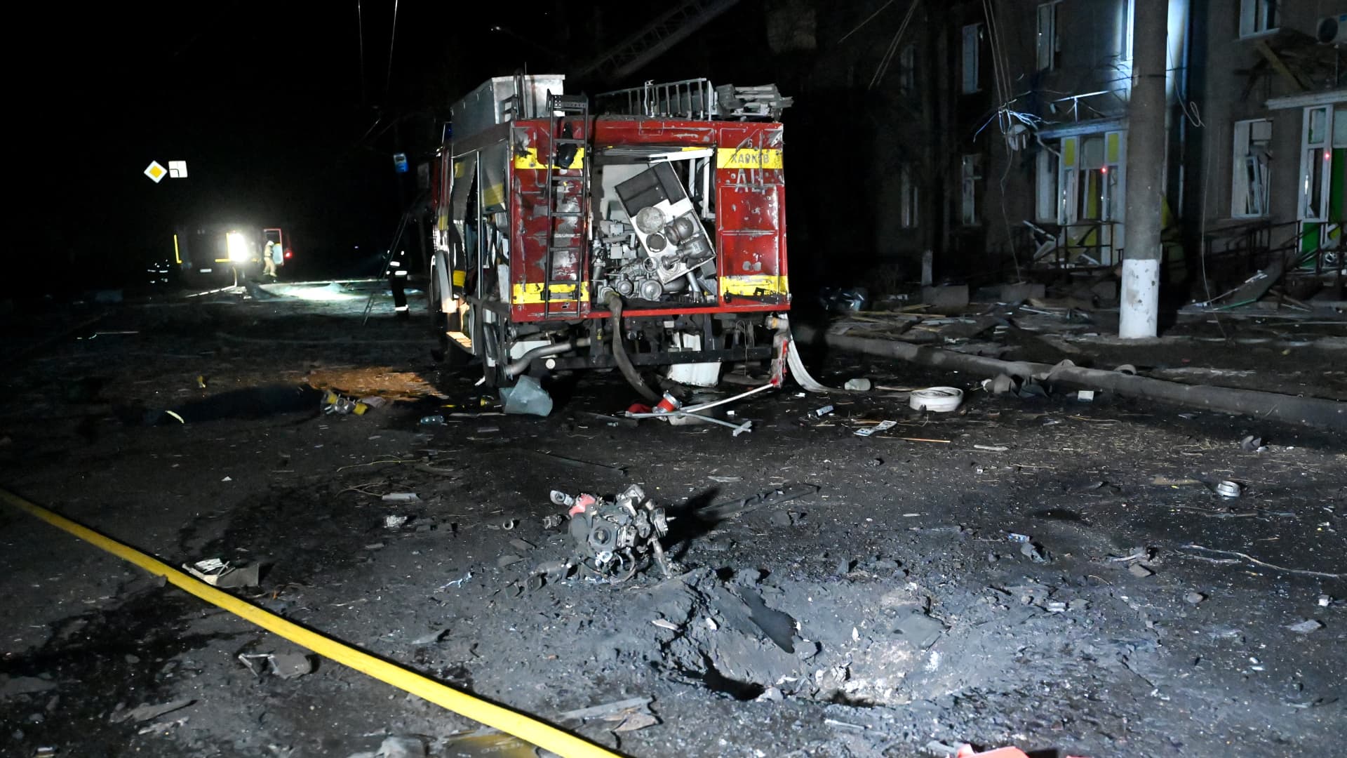 This photograph taken on April 4, 2024 shows a crater next to a damaged emergency vehicle following a drone attack in Kharkiv, amid the ongoing Russian-Ukrainian conflict. Russian air strikes overnight in Ukraine's second largest city Kharkiv killed four people and injured 11, officials said on April 4, 2024.