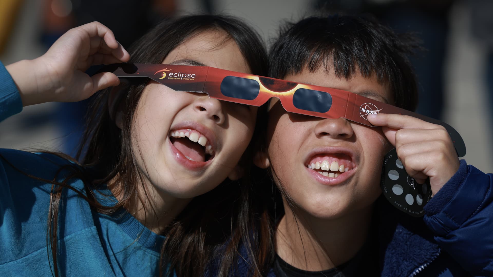 Miriam Toy (L) and Oliver Toy share a pair of eclipse glasses that NASA was handing out as they await the eclipse on April 08, 2024, in Houlton, Maine. 