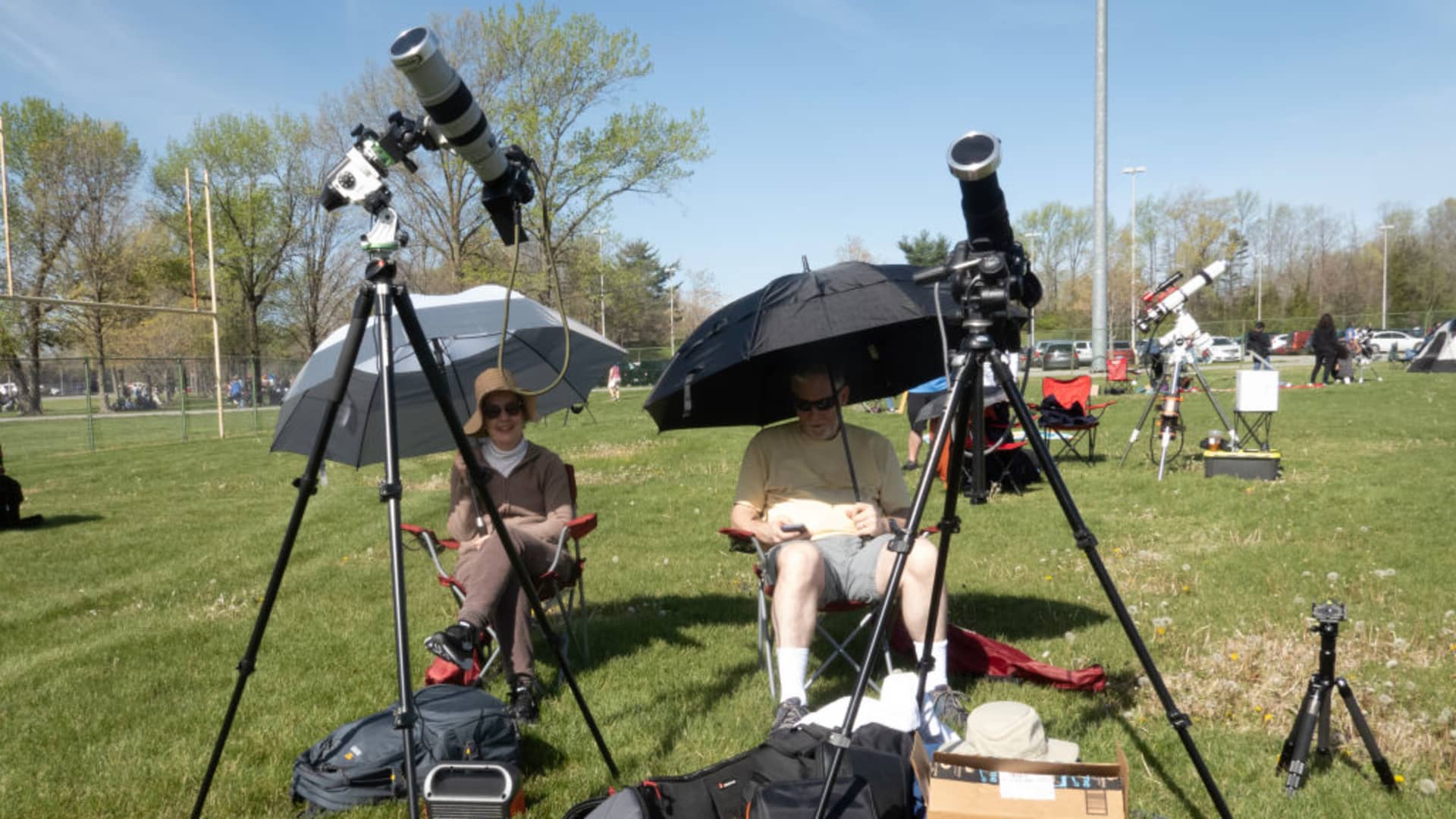 People gather in a field on the campus of Southern Illinois University to prepare for the start of the total eclipse on April 08, 2024 in Carbondale, Illinois.