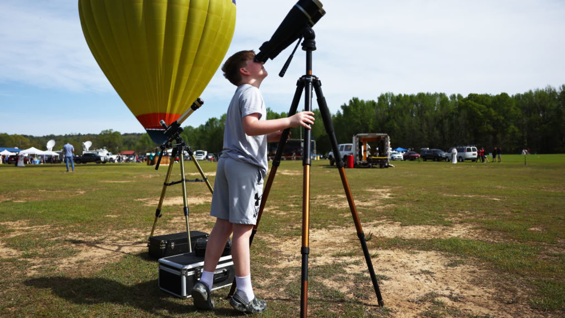 A youngster looks at the sun through binoculars at the Total Eclipse of the Heart festival on April 8, 2024 in Russellville, Arkansas.