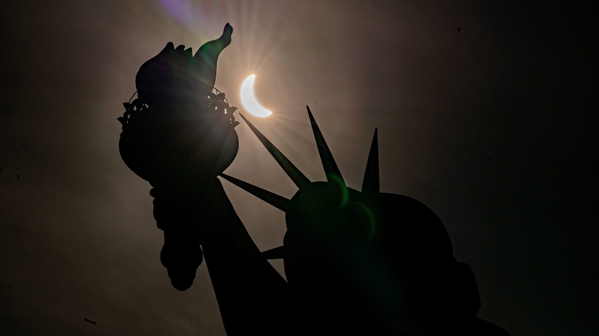 The Statue of Liberty is seen during a partial solar eclipse, where the moon partially blocks out the sun, at Liberty Island in New York City, U.S., April 8, 2024. 