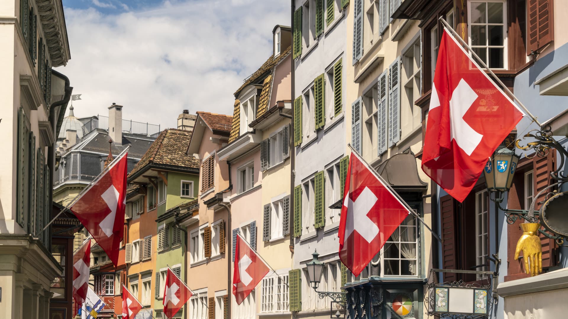 Swiss flags on houses along a street in Zug, Switzerland.