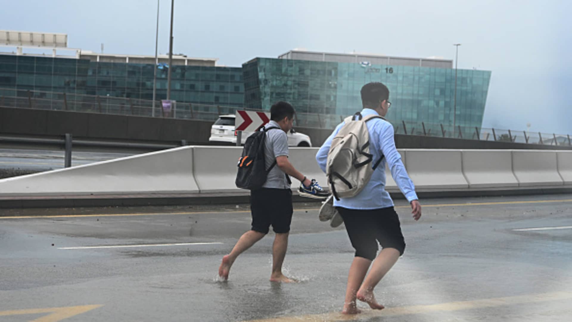 Pedestrians cross a flooded street in Dubai.