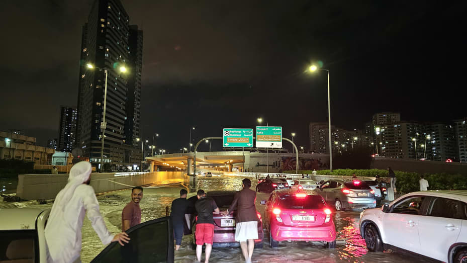 Emiratos Árabes Unidos - 16 de abril: La gente camina por una calle sumergida después de una fuerte lluvia en los Emiratos Árabes Unidos el 16 de abril de 2024. (Foto de Stringer/Anadolu vía Getty Images)