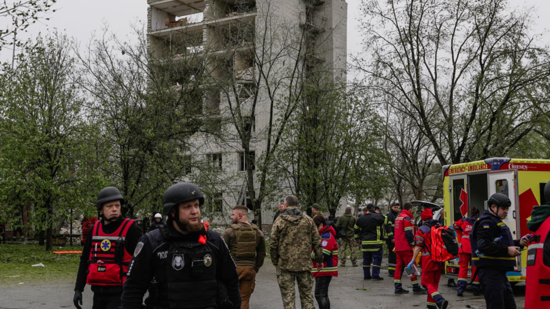 Police and military members stand in front of object of social infrastructure destroyed as result of missile attack on April 17, 2024 in Chernihiv, Ukraine. 