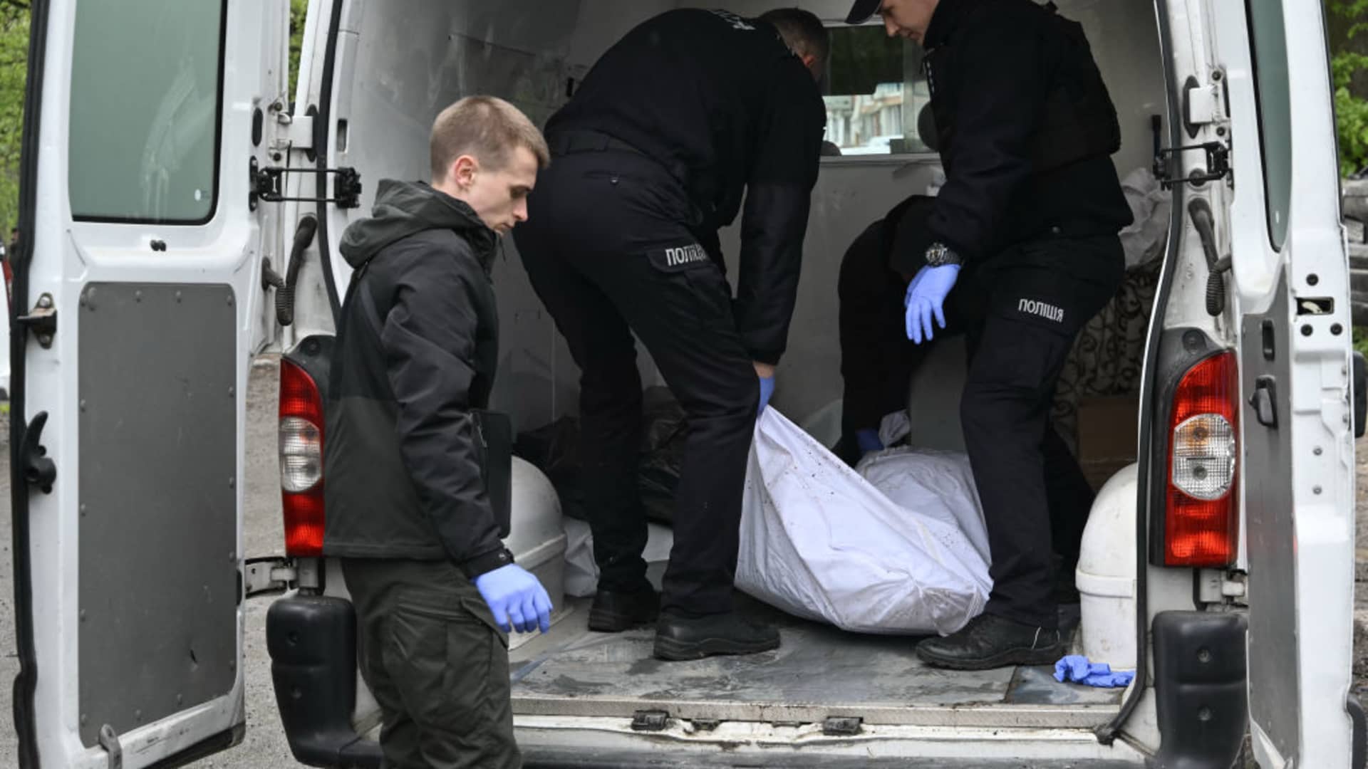 Ukrainian police officers load the body of a killed person into a car following a missile attack in Chernigiv on April 17, 2024, amid the Russian invasion of Ukraine. 