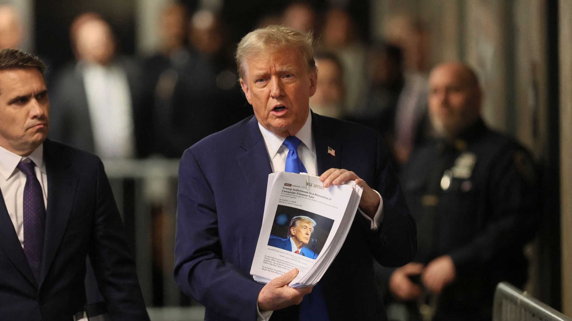Former U.S. President Donald Trump holds news clippings, as his trial continues over charges that he falsified business records to conceal money paid to silence porn star Stormy Daniels in 2016, in Manhattan state court in New York City, U.S. April 18, 2024. 