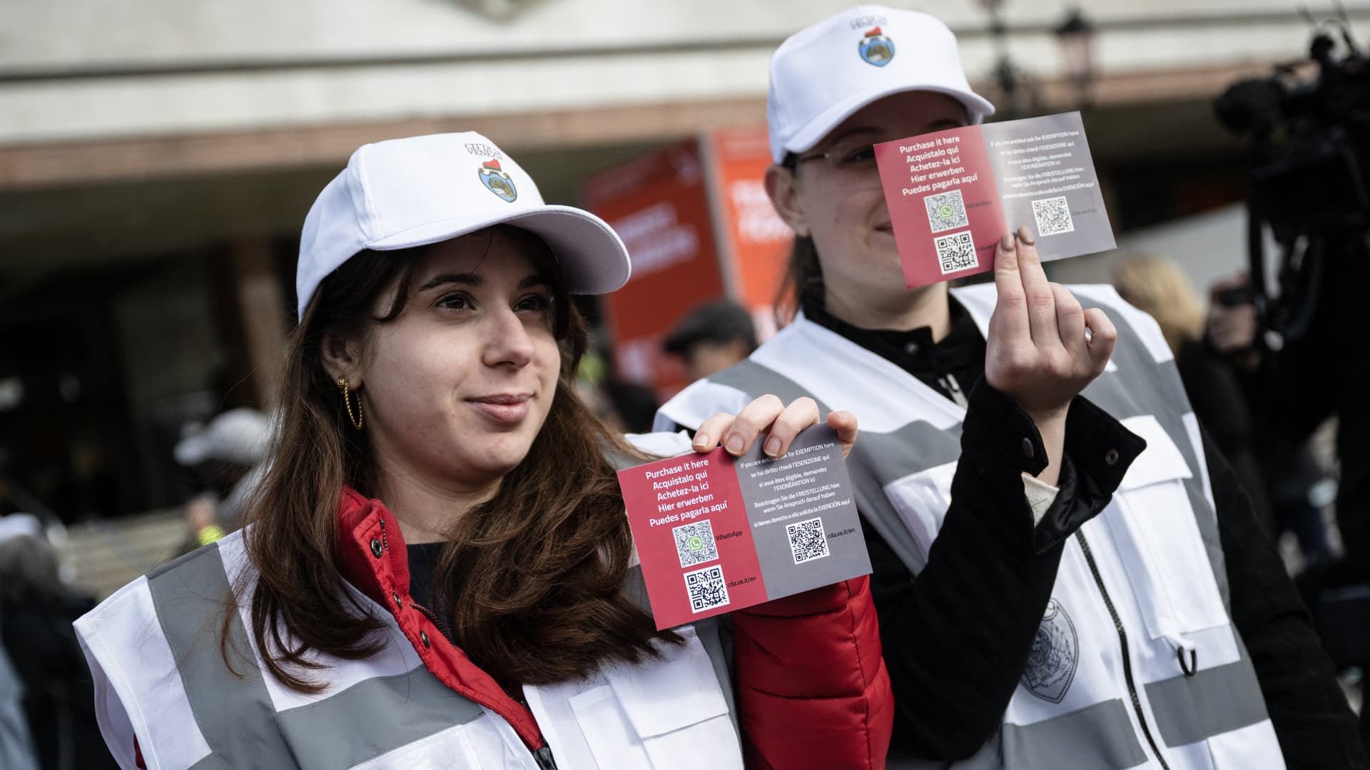 Municipal workers of Venice, show information postcards with QR code to buy ticket for entering the city, in front of the Santa Lucia railway station as they wait to buy tickets, as visitors entering the UNESCO World Heritage site for one day have to buy a five-euro ($5.3) ticket, in Venice on 25 April 2024. 