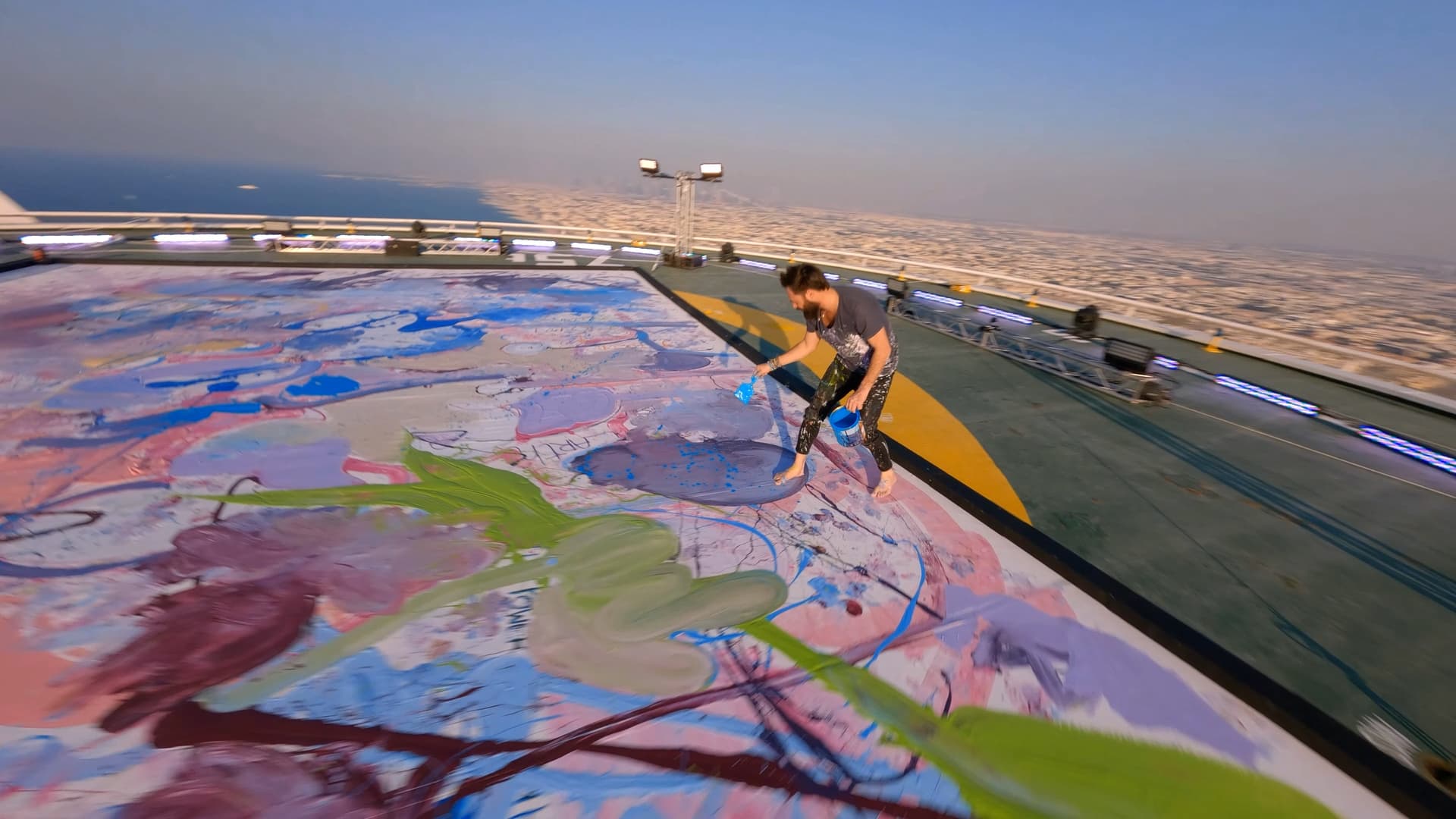 Artist Sacha Jafri painting on the helipad at the Burj Al Arab Jumeirah hotel in Dubai. He held an exhibition of 30 works on the landing pad in 2022.