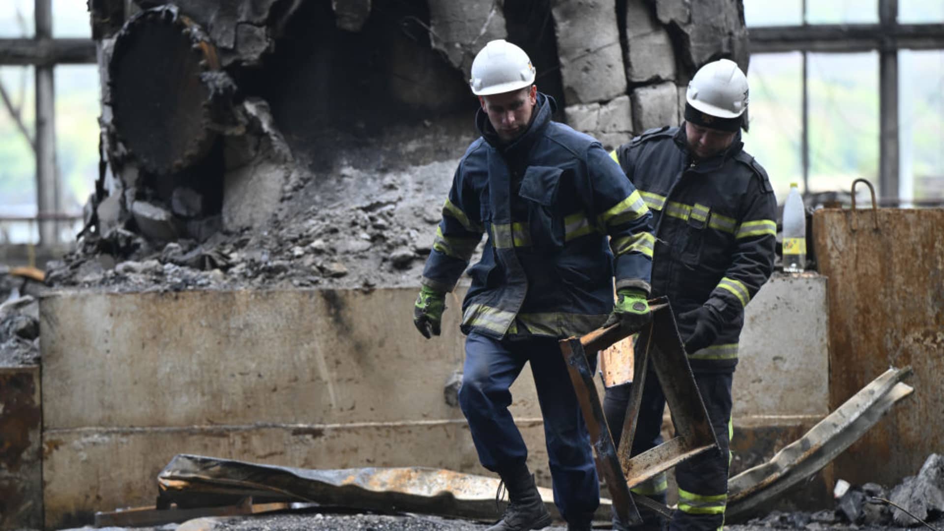 Rescuers clean debris in a turbine hall full of scorched equipments at a power plant of energy provider DTEK, destroyed after an attack, in an undisclosed location in Ukraine on April 19, 2024, amid the Russian invasion of Ukraine.